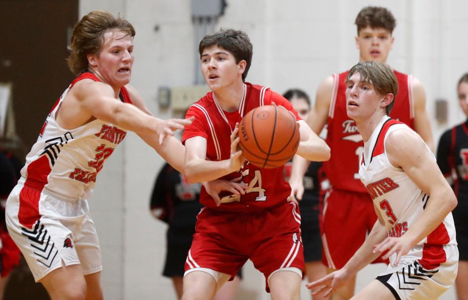 Twin Lakes Jamison Ousley (24) is guarded by Frontier Falcons Joey Schroeder (32) and Frontier Falcons Reid Duncan (3) during the IHSAA boy’s basketball game, Tuesday, Dec. 19, 2023, at Frontier Elementary School in Brookston, Ind. Twin Lakes won 64-33. The gym at Frontier Elementary School used to be the home of Brookston High School, before consolidating with Chalmers High School to form Frontier High School.