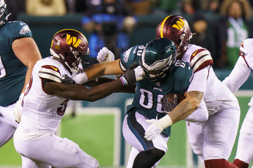 Washington Commanders linebacker Jamin Davis (52) gets his hand in Philadelphia Eagles tight end Dallas Goedert (88) helmet as Goedert runs with the ball with Washington Commanders defensive tackle John Ridgeway (91) coming from behind during the NFL football game, Monday, Nov. 14, 2022, in Philadelphia. (AP Photo/Chris Szagola)