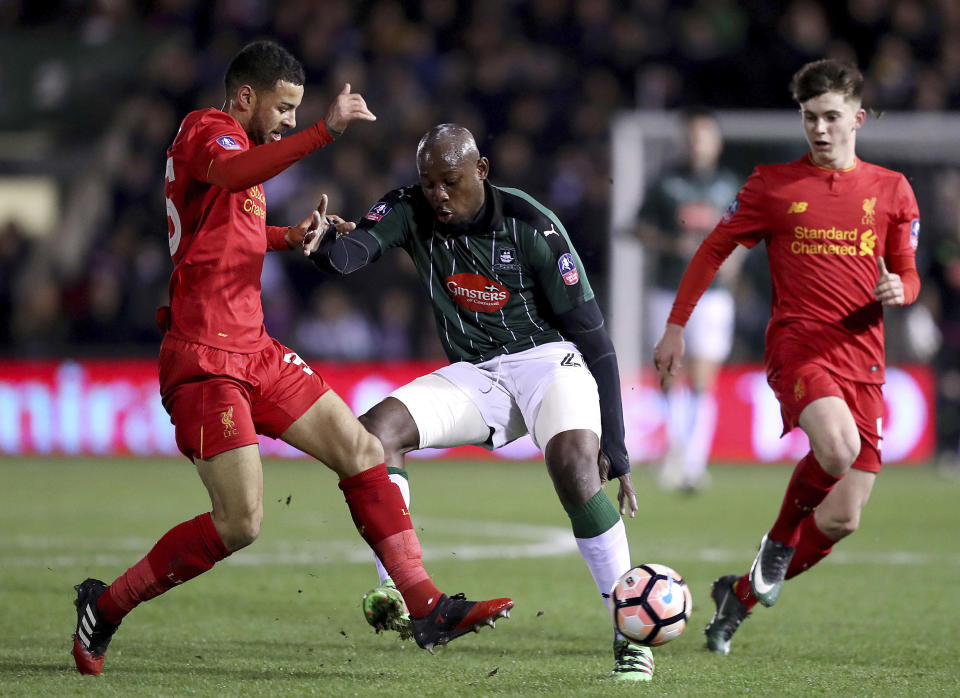 Plymouth Argyle's Paul Arnold Garita, center, and Liverpool's Kevin Stewart battle for the ball during the English FA Cup, third round replay match at Home Park, Plymouth, England, Wednesday Jan. 18, 2017. (Andrew Matthews/PA via AP)