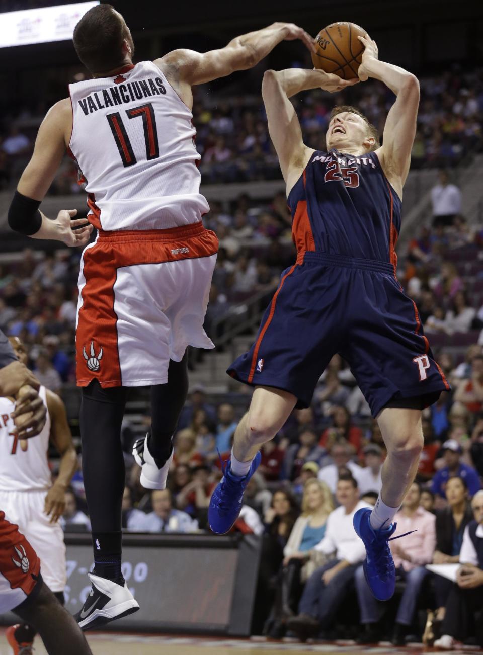 Detroit Pistons forward Kyle Singler (25) shoots over Toronto Raptors center Jonas Valanciunas (17) of Lithuania during the first half of an NBA basketball game in Auburn Hills, Mich., Sunday, April 13, 2014. (AP Photo/Carlos Osorio)