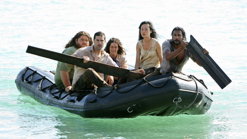 Five people paddling a dingy in the ocean; still from 'Lost'
