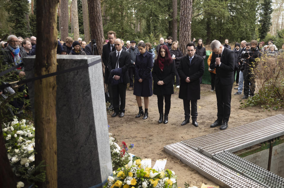 People gather for the burial of bones found on the grounds of the Freie Universitat, Free University, at the Waldfriedhof in Berlin, Germany, Thursday, March 23, 2023. Thousands of bone fragments found in the grounds of a Berlin university where an institute for anthropology and eugenics was once located, which may include the remains of victims of Nazi crimes, were buried on Thursday. (AP Photo/Markus Schreiber)