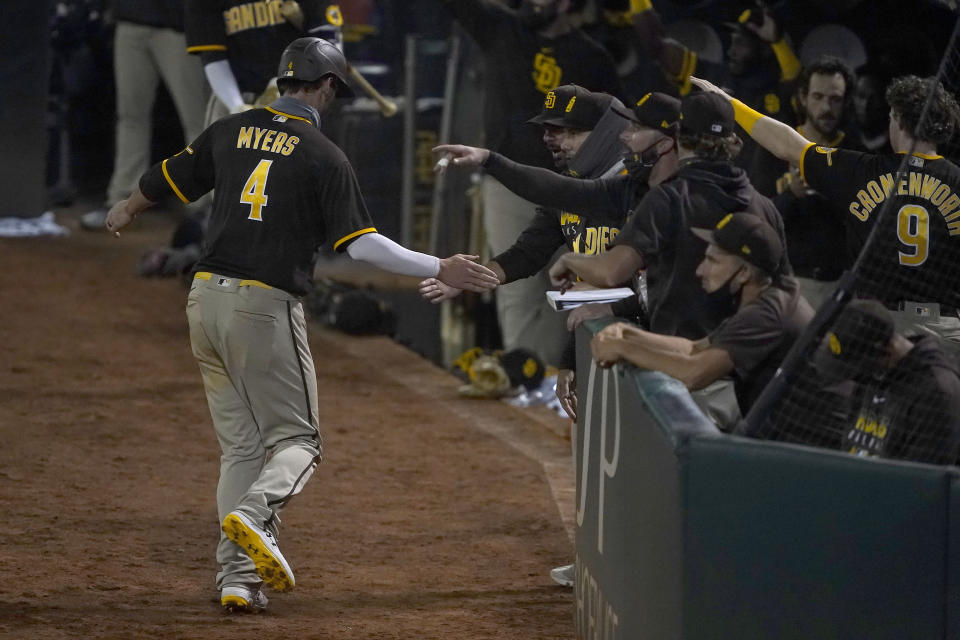 San Diego Padres' Wil Myers (4) is congratulated by teammates after scoring a run on a double by Trent Grisham during the fifth inning against the Oakland Athletics in a baseball game in Oakland, Calif., Friday, Sept. 4, 2020. (AP Photo/Tony Avelar)