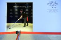 A worker vacuum-cleans the carpet inside the Congress Center of the 47th annual meeting of the World Economic Forum, WEF, in Davos, Switzerland, Monday, Jan. 16, 2017. (Laurent Gillieron/Keystone via AP)