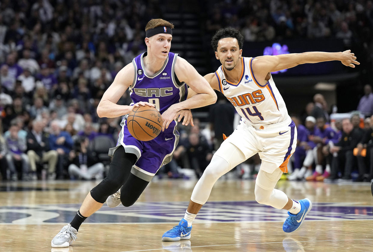 SACRAMENTO, CALIFORNIA - MARCH 24: Kevin Huerter #9 of the Sacramento Kings drives to the basket past Landry Shamet #14 of the Phoenix Suns during the third quarter of an NBA basketball game at Golden 1 Center on March 24, 2023 in Sacramento, California. NOTE TO USER: User expressly acknowledges and agrees that, by downloading and or using this photograph, User is consenting to the terms and conditions of the Getty Images License Agreement. (Photo by Thearon W. Henderson/Getty Images)
