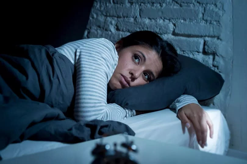 young beautiful hispanic woman at home bedroom lying in bed late at night trying to sleep suffering insomnia sleeping disorder or scared on nightmares looking sad worried and stressed