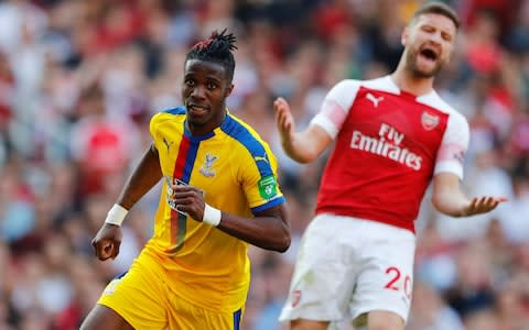 Crystal Palace's Wilfried Zaha celebrates scoring their second goal as Shkodran Mustafi looks dejected  - Credit: Reuters