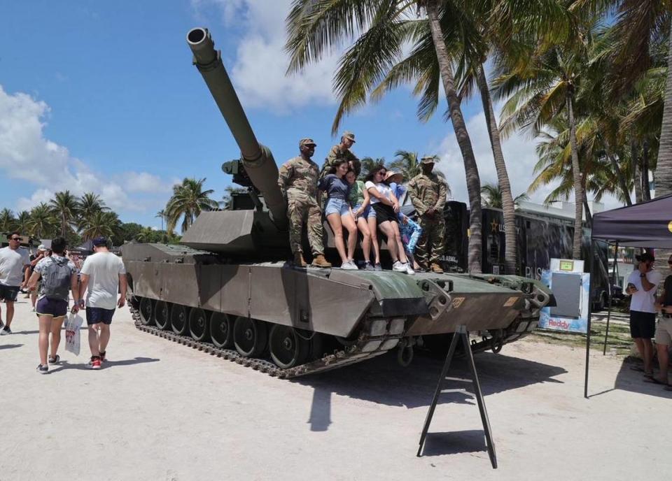 Miembros del ejército y asistentes posando con un tanque en Hyundai Air and Sea Show 2023 en Miami Beach el sábado 27 de mayo de 2023.