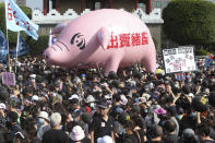 People hold a pig model with a slogan "Betraying pig farmers" during a protest in Taipei, Taiwan, Sunday, Nov. 22. 2020. Thousands of people marched in streets on Sunday demanding the reversal of a decision to allow U.S. pork imports into Taiwan, alleging food safety issues. (AP Photo/Chiang Ying-ying)