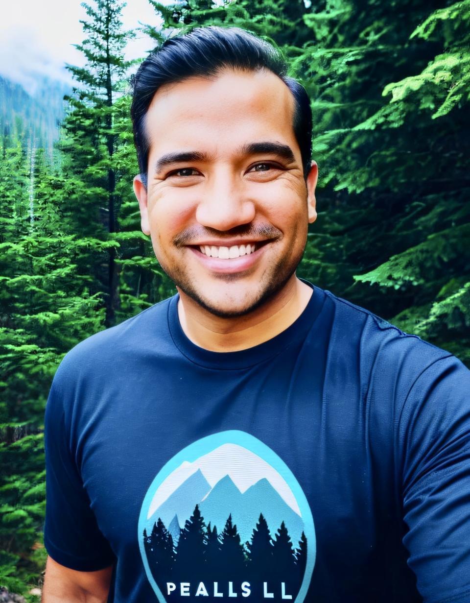 Kiran Krishnan, a microbiologist, smiles in a headshot outside near pine trees