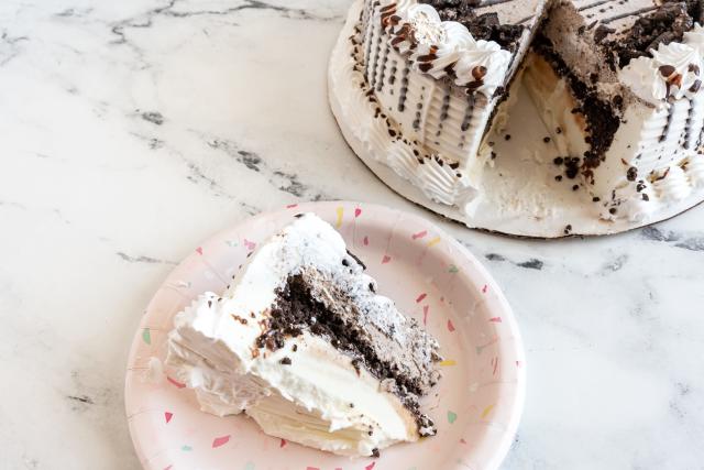 a sice of drizzled chocolate ice cream cake on a white counter