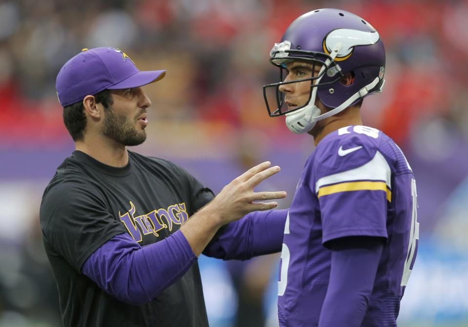 Minnesota Vikings quarterback Cassel listens to injured quaterback Ponder before the Vikings met the Pittsburgh Steelers in their NFL football game at Wembley Stadium in London