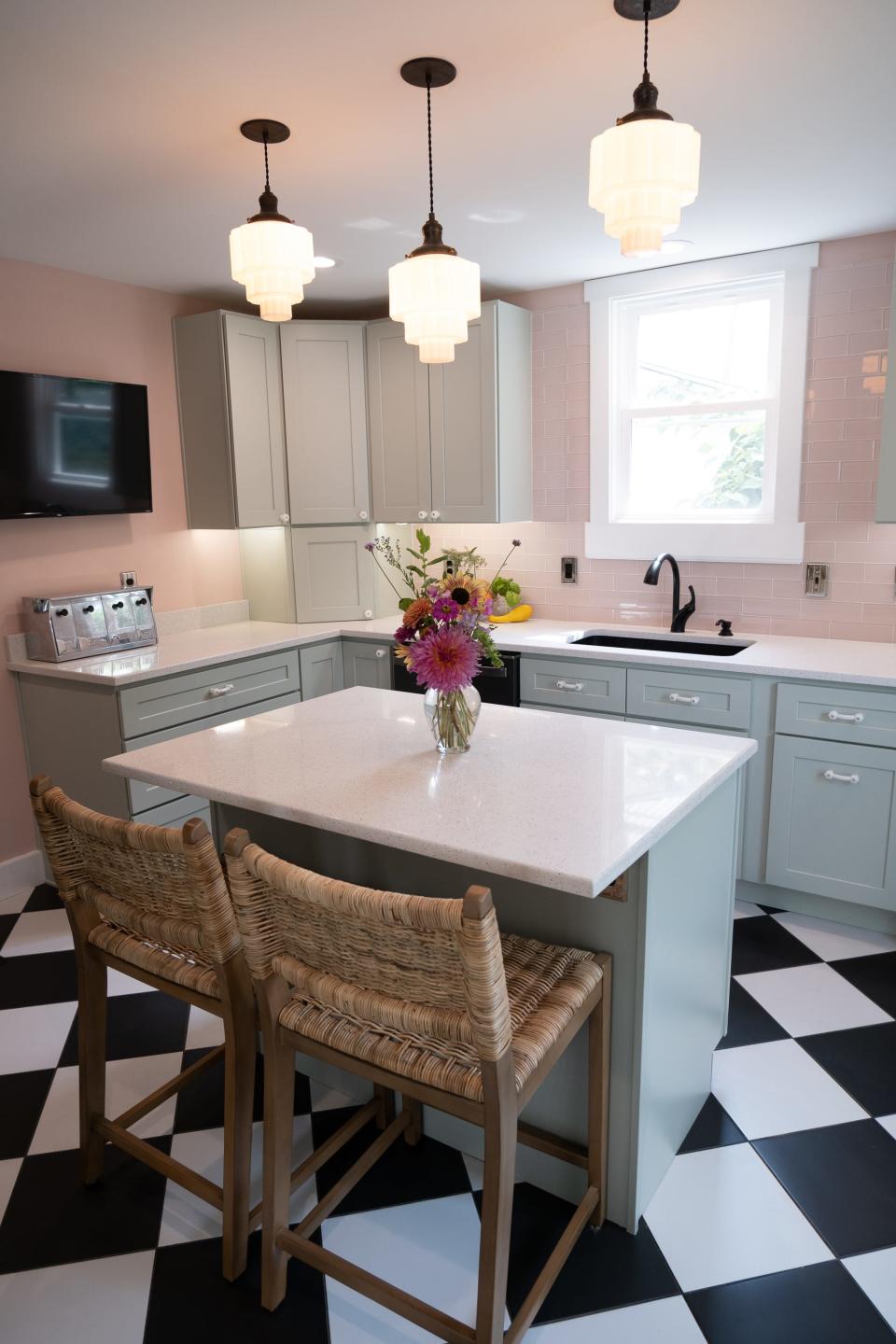 Two wicker bar stools invite casual dinners at home, and a splash of vibrant color comes courtesy of fresh blooms from their garden in this renovated kitchen in Louisville's Clifton neighborhood.