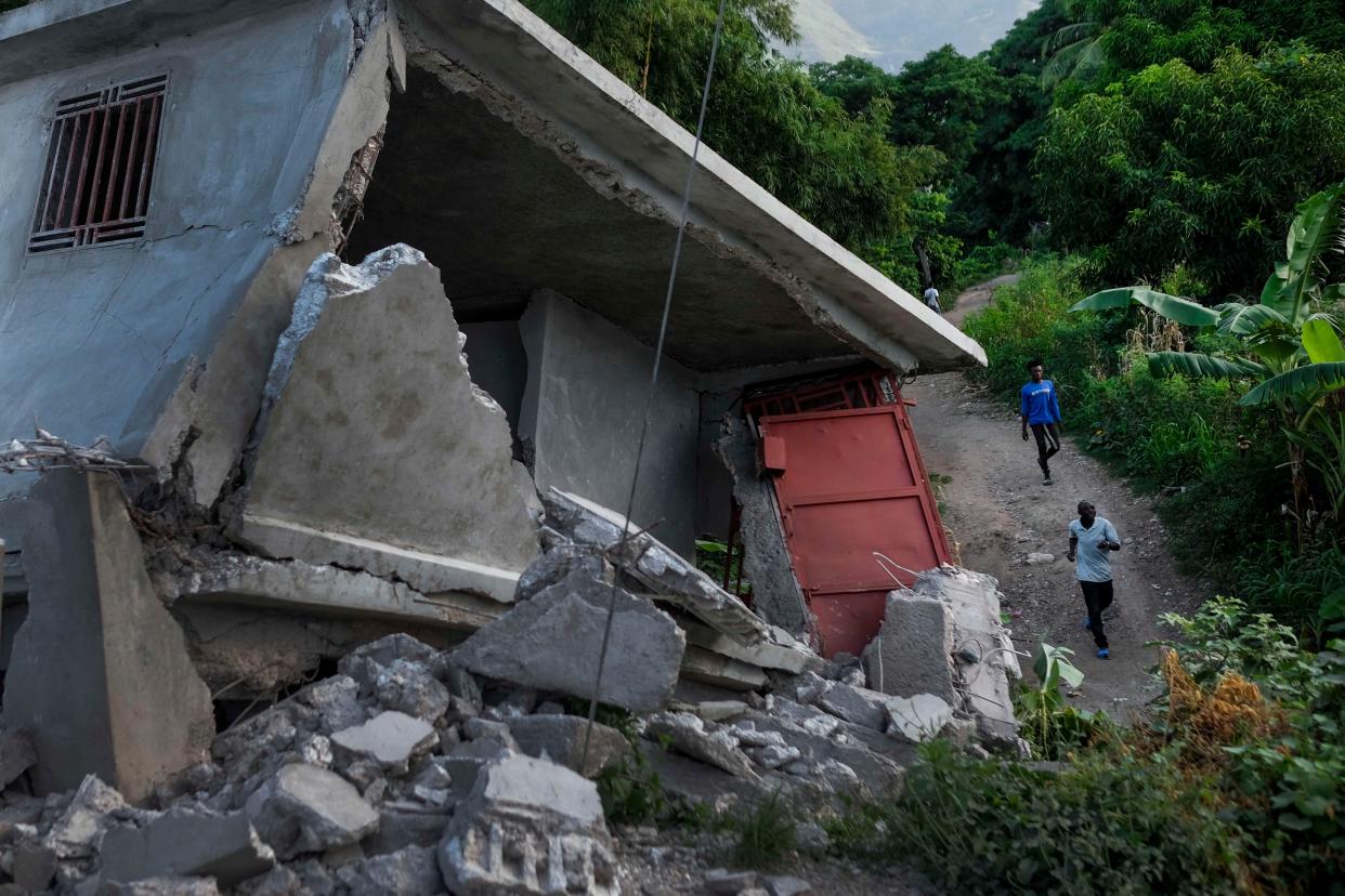 Residents walk past a collapsed building in Saint-Louis-du-Sud, Haiti on Monday, Aug. 16, 2021. A 7.2-magnitude earthquake struck the southwestern part of the hemisphere's poorest nation on Aug. 14.