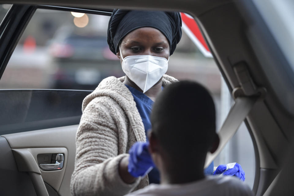 COVID-19 Response representative Hadja Bah administers a test to a child, Friday, Oct. 22, 2021, in Marietta, Ga. When Marietta City Schools started the 2021-2022 school year, the Georgia district that serves 9,000 quickly had to quarantine about 10% of its students and staff. (AP Photo/Mike Stewart)