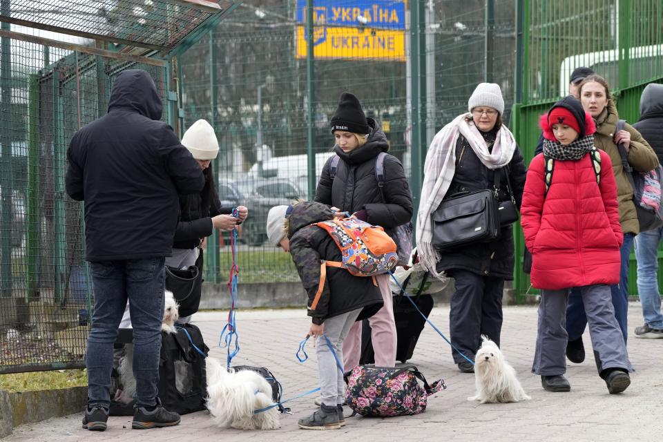 People fleeing the conflict from neighboring Ukraine, arrive at the border crossing in Medyka, southeastern Poland, on Friday, Feb. 25, 2022. Russia pressed its invasion of Ukraine to the outskirts of the capital Friday after unleashing airstrikes on cities and military bases and sending in troops and tanks from three sides in an attack that could rewrite the global post-Cold War security order. (AP Photo/Czarek Sokolowski)