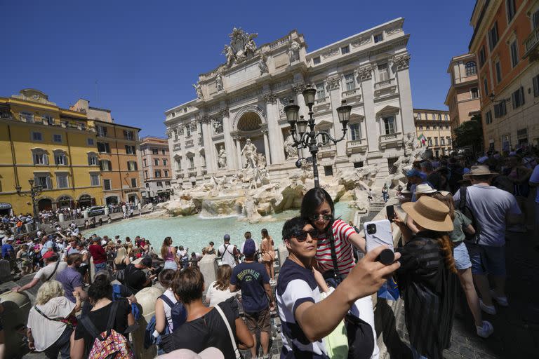 Los turistas se toman una selfie frente a la Fontana de Trevi, en Roma, el lunes 20 de junio de 2022