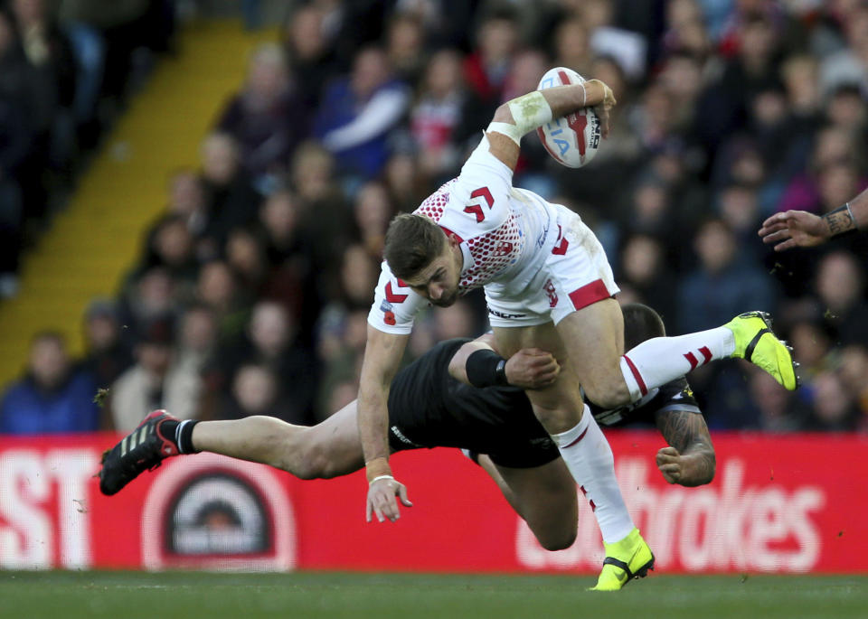 England's Tommy Makinson tries to skip past a tackle by New Zealand's Jared Waerea-Hargreaves during their International Rugby League match, at Elland Road in Leeds, England, Sunday Nov. 11, 2018. (Richard Sellers/PA via AP)