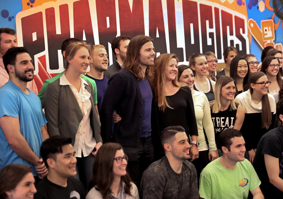 PharmaLogics employees pose with their CEO Megan Driscoll (center right) and Dan Price (center left),&nbsp;who influenced Megan's decision to&nbsp;increase her workers' salaries.&nbsp; (Photo: Boston Globe/RM)