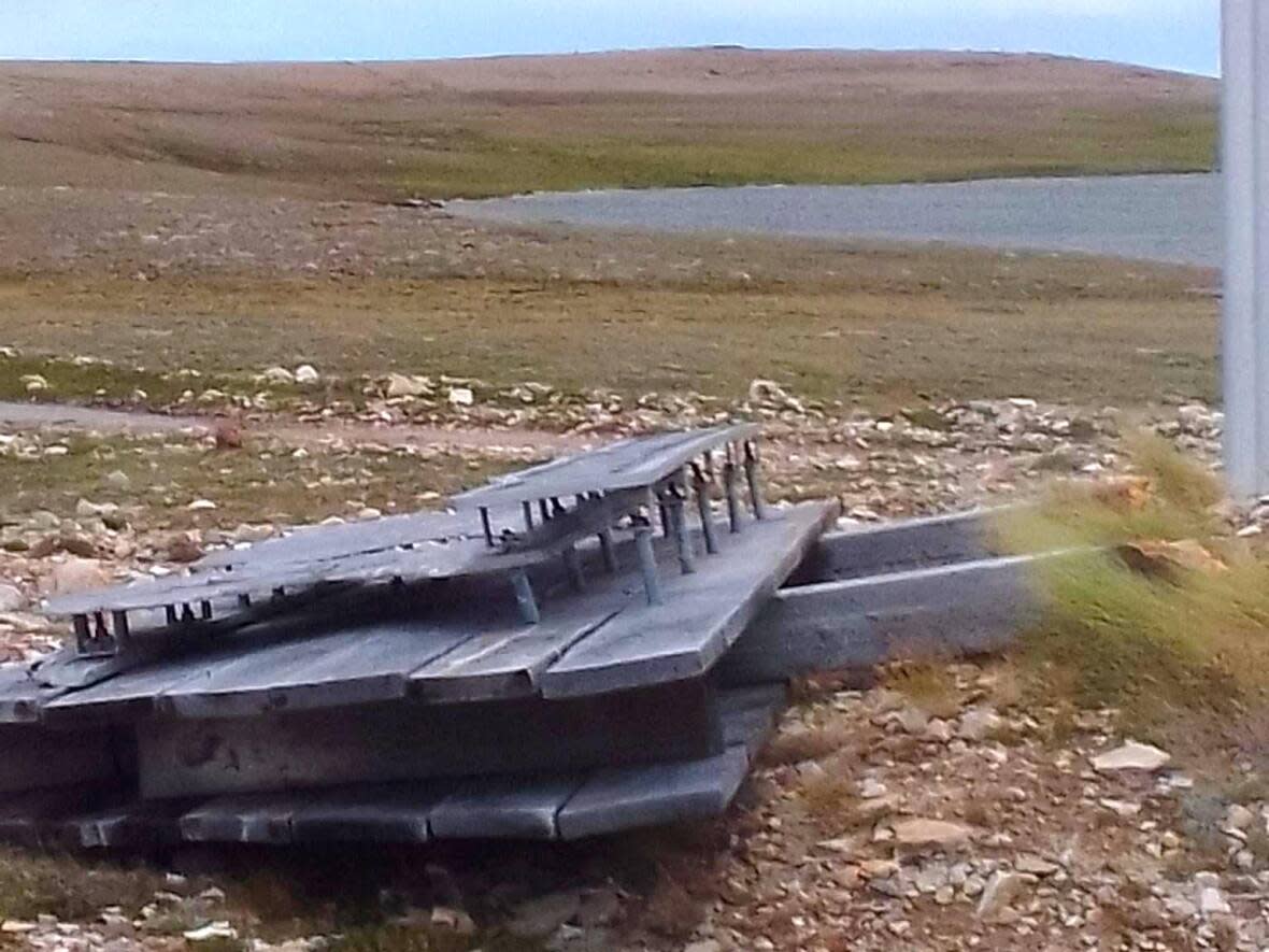 The sign at the Ovayok Territorial Park entrance near Cambridge Bay lies on the ground after what Environment Canada called unusual wind gusts on Thursday.  (Submitted by Curtis Norberg - image credit)