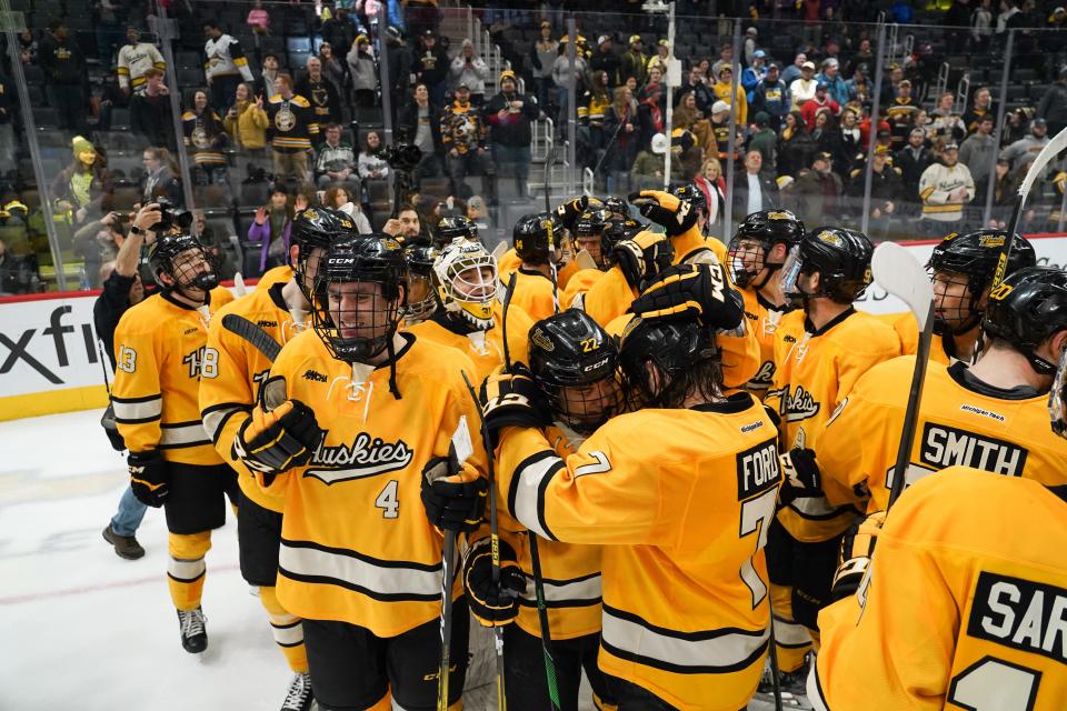 Members of the Michigan Tech Huskies celebrate a win over the University of Michigan during the championship game of the 55th annual Great Lakes Invitational at Little Caesars Arena in Detroit on Tuesday, December 31, 2019.