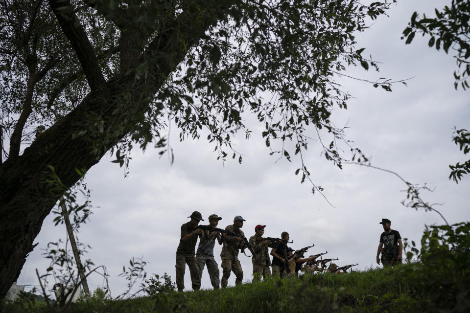 In this July 29, 2018 photo, Yuri "Chornota" Cherkashin, head of Sokil (Falcon), the youth wing of the nationalist Svoboda party, gives tactical instructions to young participants of the "Temper of will" summer camp in a village near Ternopil, Ukraine. "We never aim guns at people," Cherkashin tells his students. "But we don't count separatists, little green men, occupiers from Moscow as people, so we can and should aim at them." (AP Photo/Felipe Dana)