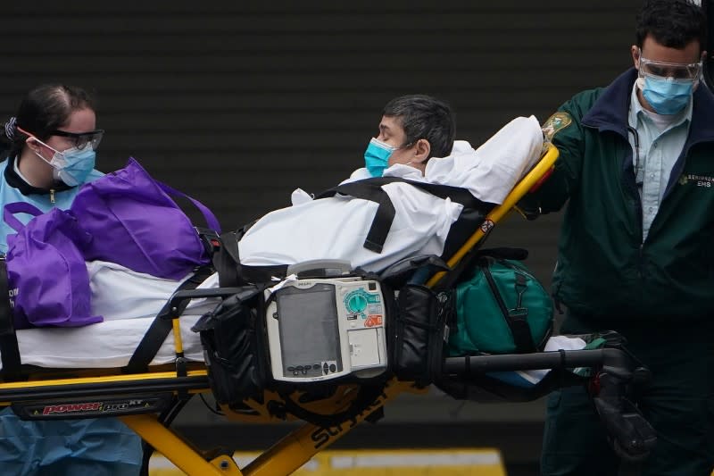 Paramedics move a patient into the hospital during the outbreak of coronavirus disease (COVID-19), in the Manhattan borough of New York City