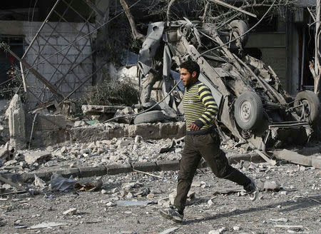 A man runs after an air raid in the besieged town of Douma, Eastern Ghouta, Damascus, Syria February 23, 2018. REUTERS/Bassam Khabieh