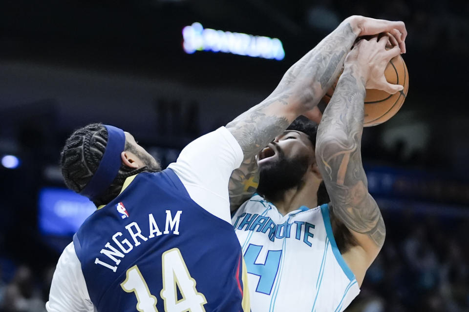 New Orleans Pelicans forward Brandon Ingram (14) stops Charlotte Hornets center Nick Richards (4) as he drives to the basket in the first half of an NBA basketball game in New Orleans, Wednesday, Jan. 17, 2024. (AP Photo/Gerald Herbert)