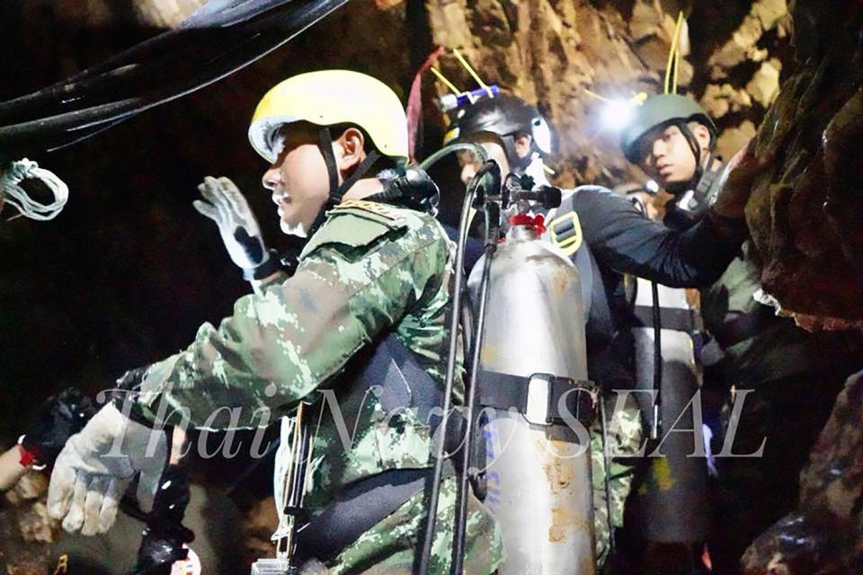 A Thai Navy officer and rescuers work inside a cave complex during the ongoing rescue operations for the stranded soccer team at Tham Luang cave. Source: AAP