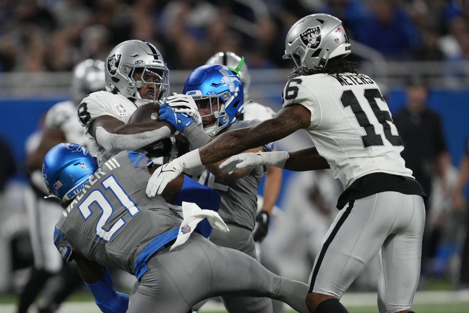 Las Vegas Raiders running back Josh Jacobs (8) is tackled by Detroit Lions safety Tracy Walker III (21) during the first half of an NFL football game, Monday, Oct. 30, 2023, in Detroit. (AP Photo/Paul Sancya)