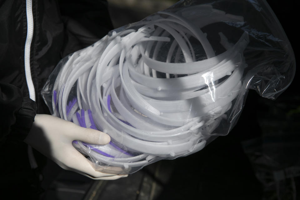 High school junior, Will Olsen, 17, of Kensington, Md., holds a bag of pieces for medical face shields that were printed using personal 3D printers, in Kensington, Md., Sunday, April 19, 2020. The pieces are delivered to the Eaton Hotel in downtown Washington for assembly. (AP Photo/Jacquelyn Martin)