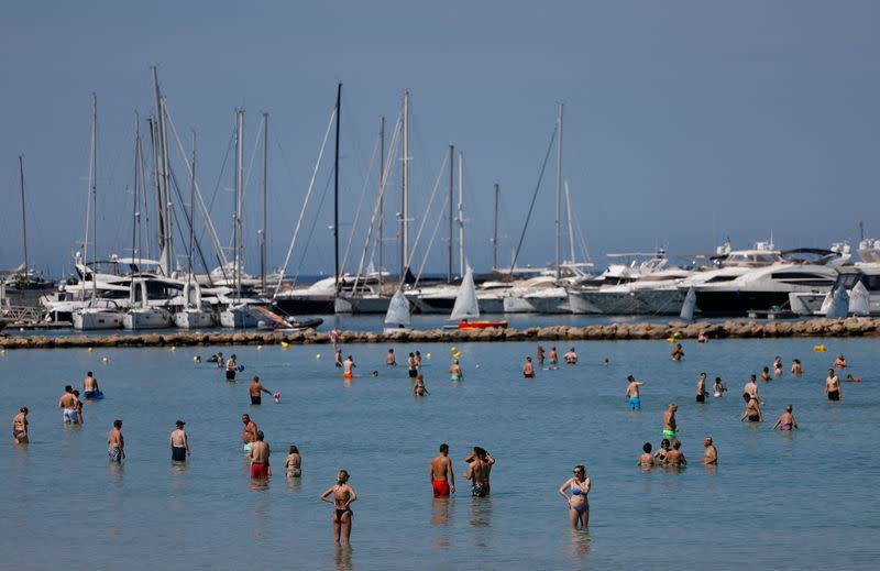 Tourists sunbathe in El Arenal beach in the island of Mallorca