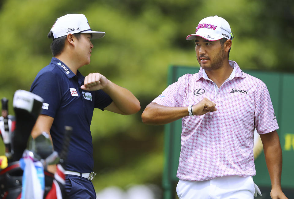 Sungjae Im, left, and Hideki Matsuyama give each other an elbow bump as they take the first tee to begin their first round of the Tour Championship golf tournament at East Lake Golf Club on Friday, Sept. 4, 2020, in Atlanta. (Curtis Compton/Atlanta Journal-Constitution via AP)