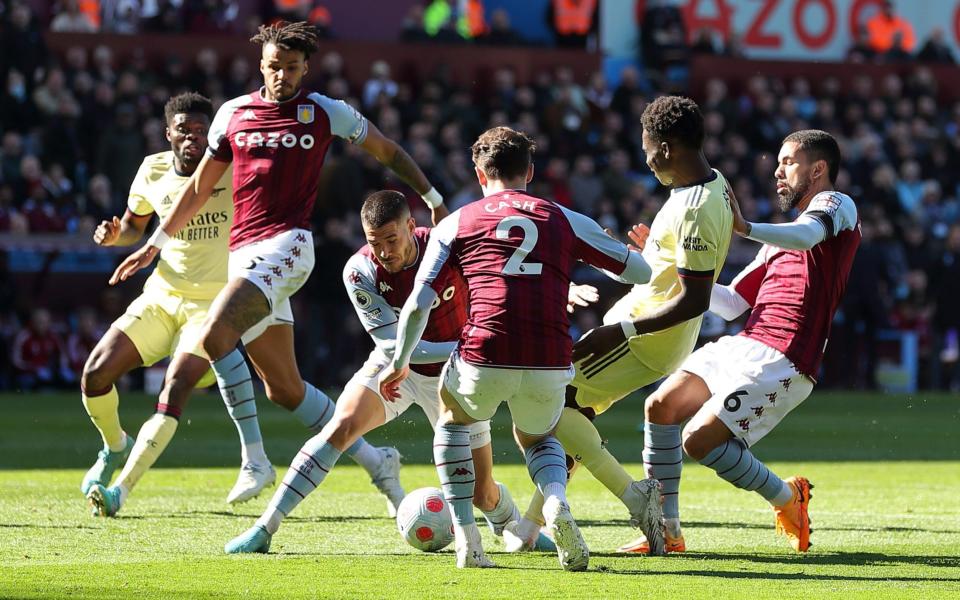 Emiliano Buendia, Matty Cash and Douglas Luiz of Aston Villa tackle Bukayo Saka - Getty Images Europe