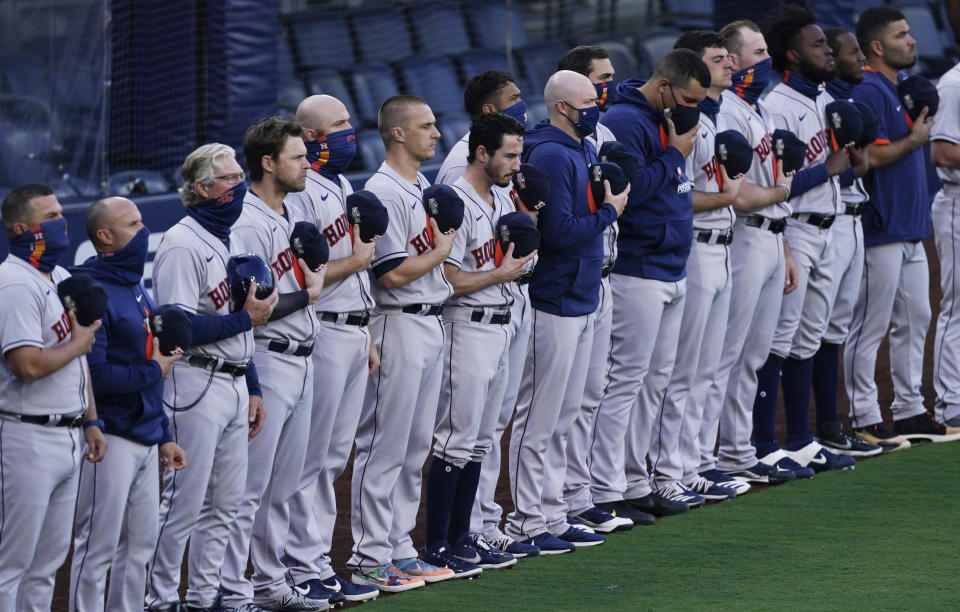 Houston Astros line up for the playing of the national anthem before Game 1 of a baseball American League Championship Series against the Tampa Bay Rays, Sunday, Oct. 11, 2020, in San Diego. (AP Photo/Ashley Landis)