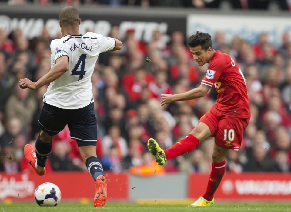 Liverpool's Philippe Coutinho, right, scores past Tottenham's Younes Kaboul during their English Premier League soccer match at Anfield Stadium, Liverpool, England, Sunday March 30, 2014. (AP Photo/Jon Super)