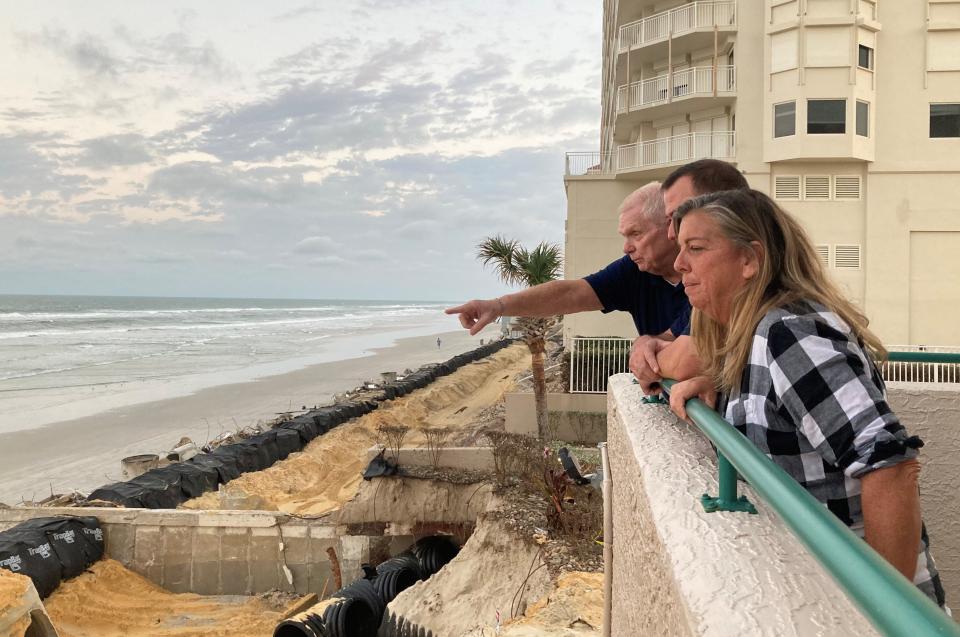 Ed Offerman points while standing next to the coastline at the south tower of the Dimucci Twin Towers on Monday, where condo owners from over a dozen buildings gathered to discuss recovery efforts. Offerman described damage and recovery efforts at the tower to Susan Furlong, front, an owner at the Bella Vista condos in Daytona Beach Shores, and Joe Crane, an owner at the White Surf condos.