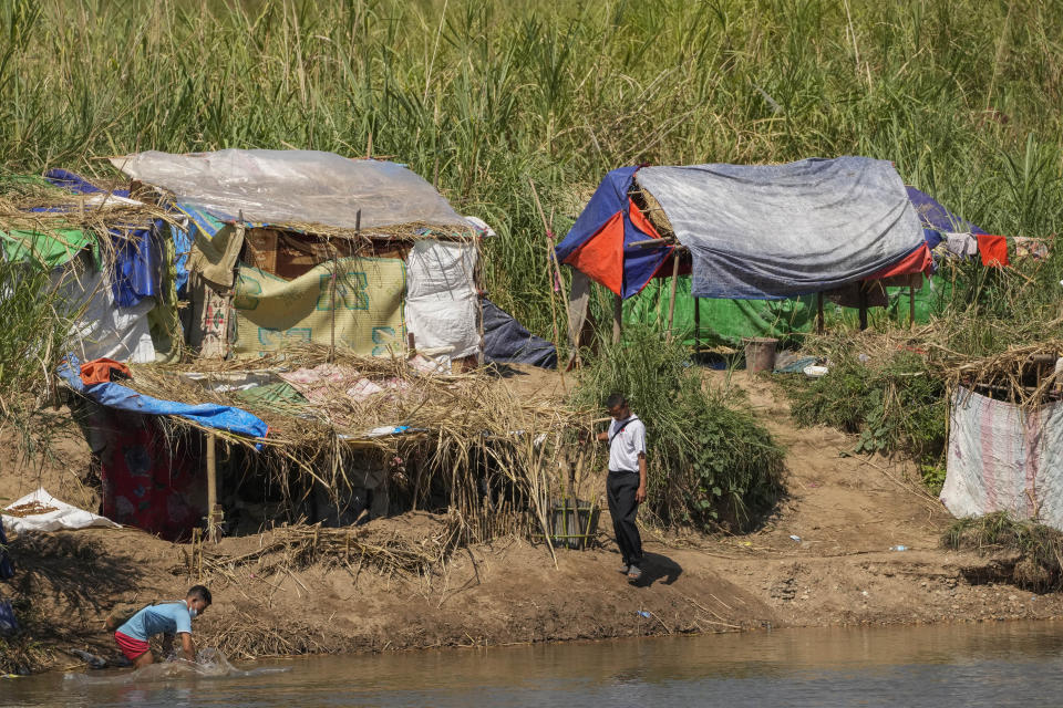 Ethnic Karen villagers, who fled recent attacks by the Myanmar military, carry on life in temporary shelters along the Moei River on the Thai-Myanmar border on Jan. 24, 2022. Since Myanmar's military dismissed the results of democratic elections and seized power on Feb. 1, 2021, peaceful nationwide protests and violent crackdowns by security forces have spiraled into a nationwide humanitarian crisis. (AP Photo/Sakchai Lalit)