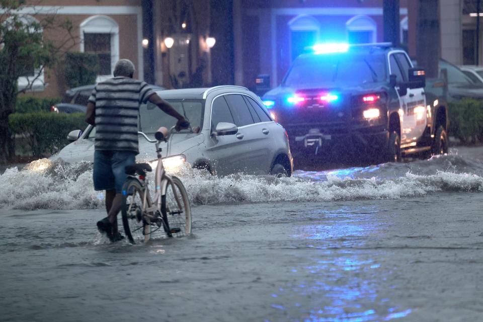 A bicyclist goes through flooded streets on Stirling Road near Federal Highway in Hollywood, Fla., Wednesday, June 12, 2024. (Mike Stocker/South Florida Sun-Sentinel via AP)