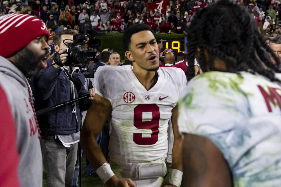 Alabama quarterback Bryce Young (9) celebrates with Alabama wide receiver John Metchie III (8) after a 24-22 4-overtime win over Auburn in an NCAA college football game, Saturday, Nov. 27, 2021, in Auburn, Ala. (AP Photo/Vasha Hunt)