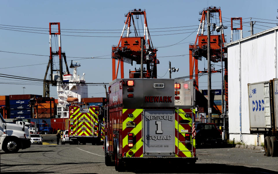 Emergency officials arrive at Port Newark to investigate reports of stowaways in a container on a ship, Wednesday, June 27, 2012, in Newark, N.J. The Coast Guard suspects there are stowaways in a container that was loaded on a ship. Coast Guard spokesman Charles Rowe says a boarding party heard sounds consistent with people coming from the container. The container was loaded aboard The Villa D'Aquarius in India. The manifest says the container was carrying machine parts to be unloaded in Norfolk, Va. (AP Photo/Julio Cortez)