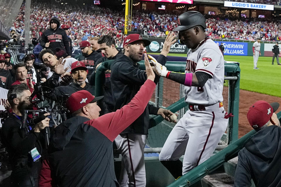 Arizona Diamondbacks' Geraldo Perdomo celebrates in the dugout after scoring on his two-run home run against the Philadelphia Phillies during the sixth inning in Game 1 of the baseball NL Championship Series in Philadelphia, Monday, Oct. 16, 2023.(AP Photo/Brynn Anderson)