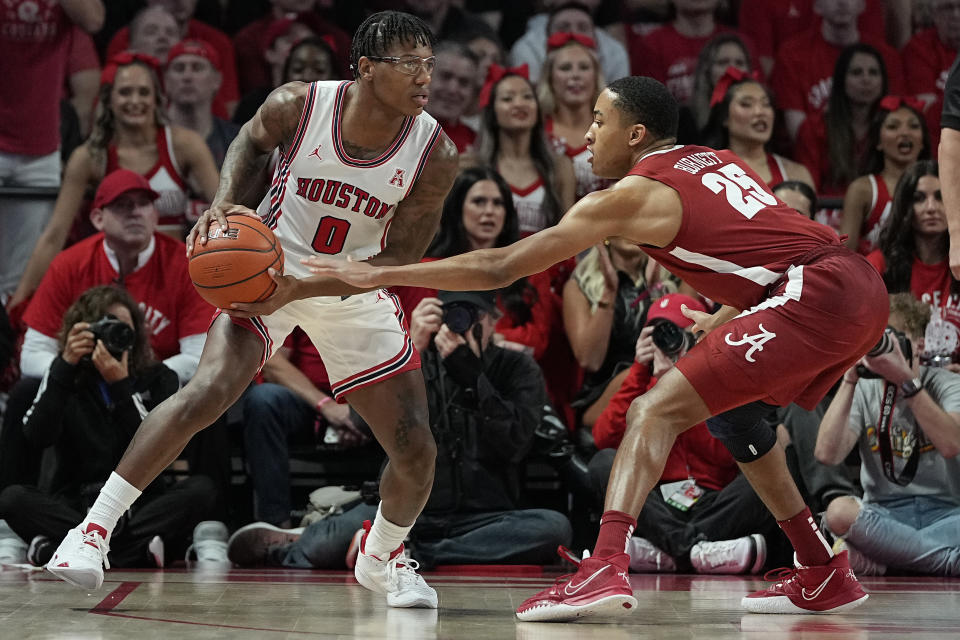 Houston guard Marcus Sasser (0) is defended by Alabama guard Nimari Burnett (25) during the first half of an NCAA college basketball game, Saturday, Dec. 10, 2022, in Houston. (AP Photo/Kevin M. Cox)