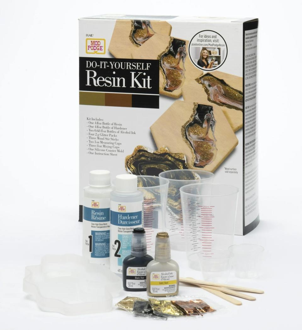 Do-It-Yourself Resin Kit with bottles, mixing cup, sticks, and images of resin art on packaging