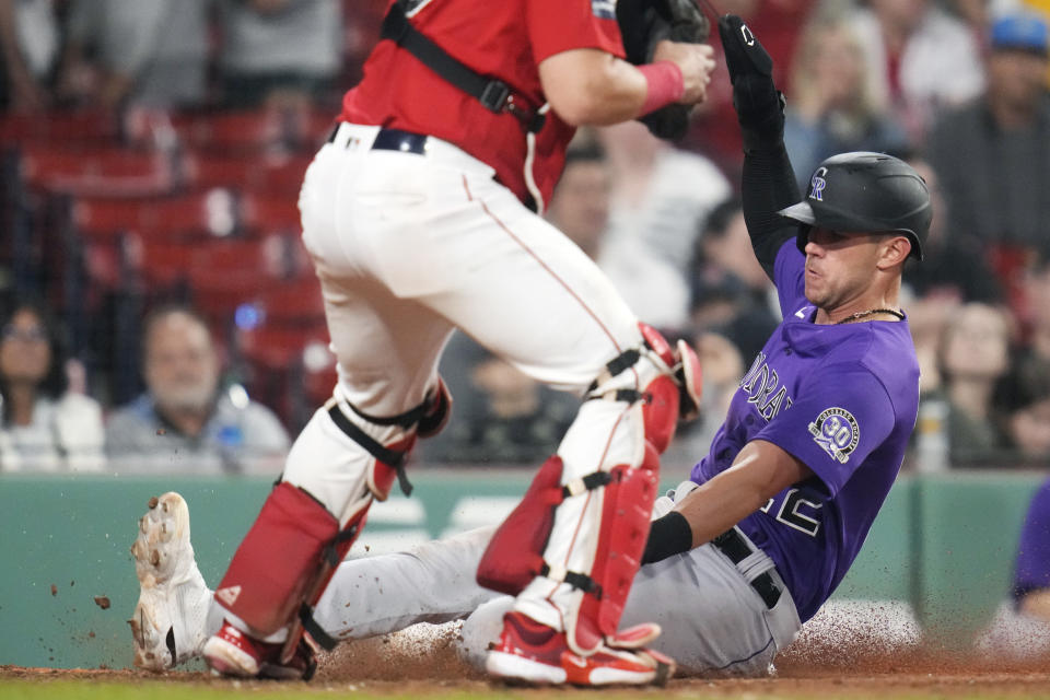 Colorado Rockies' Nolan Jones scores on a two RBI double by Randal Grichuk in the tenth inning during a baseball game against the Boston Red Soxat Fenway Park, Tuesday, June 13, 2023, in Boston. (AP Photo/Charles Krupa)