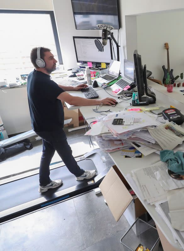 Belgian Yves Hanoulle, IT professional, walks on a treadmill as he works in his home in Ghent