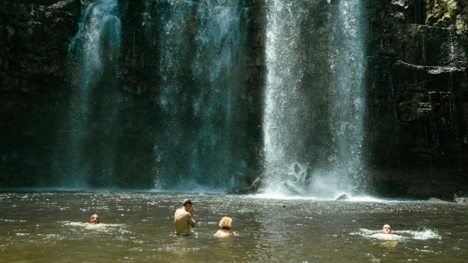 Washing off the road in a waterfall-fed swimming hole. - Credit: Hermann Koepf, courtesy of BMW Motorrad.