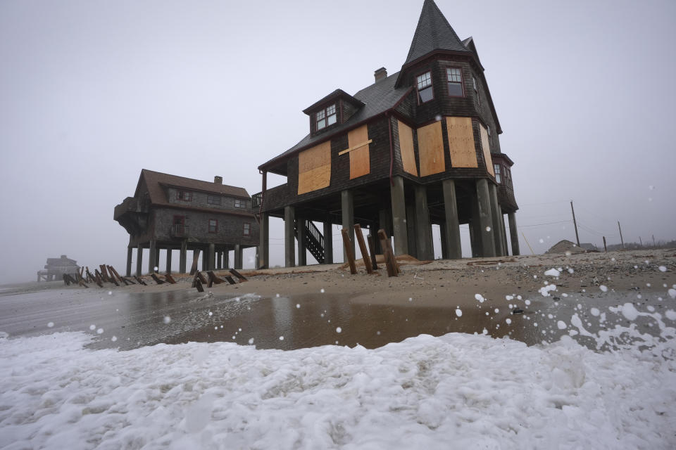 Houses resting on pylons are elevated above the beach, Thursday, Jan. 25, 2024, in South Kingstown, R.I. Experts say erosion and receding shorelines are becoming more common due to ocean rise and climate change. (AP Photo/Steven Senne)