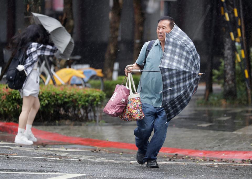 People walk in the rain as Typhoon Gaemi approaches in Taipei, Taiwan (AP)